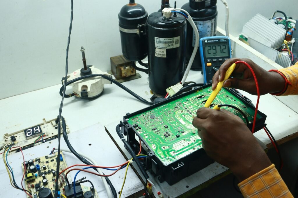 Technician working on AC PCB with tools and equipment, captured in New Delhi workshop.